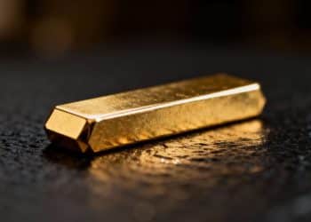 Lingot d'or brillant sur fond sombre.