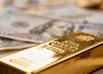 Lingot d'or avec billets de banque étrangers flous.