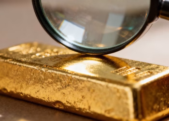 Lingot d'or sous une loupe, gros plan.