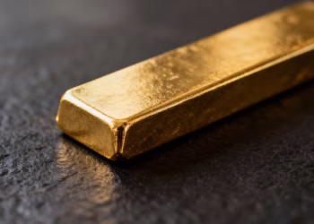 Lingot d'or brillant sur fond sombre.
