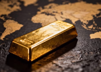 Lingot d'or sur fond de carte du monde floue.