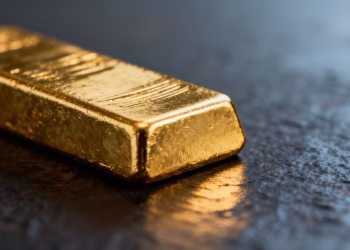 Lingot d'or brillant sur fond sombre.