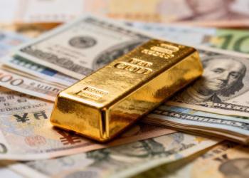 Barre d'or sur des billets de banque internationaux.