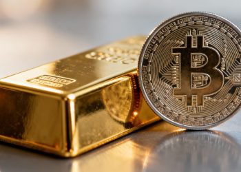 Barre d'or et pièce de cryptomonnaie numérique.