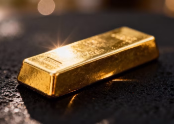 Lingot d'or sur fond sombre, reflets lumineux.