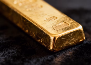 Lingot d'or brillant sur fond sombre.