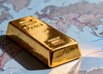 Lingot d'or sur fond de carte du monde floue.