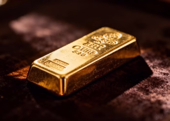 Lingot d'or brillant sur fond sombre.