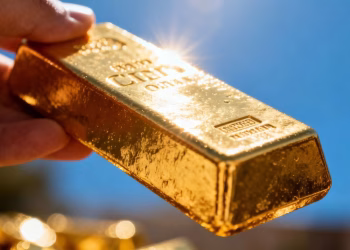 Barre d'or brillante dans une main