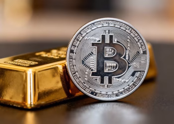 Barre d'or et pièce de cryptomonnaie côte à côte.