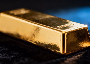 Lingot d'or brillant sur fond sombre.