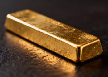 Lingot d'or brillant sur fond sombre.