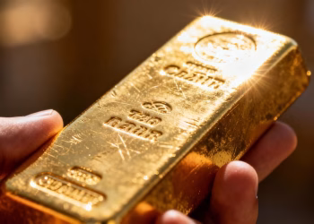 Lingot d'or brillant tenu dans une main