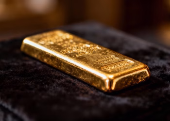 Lingot d'or brillant sur fond sombre.