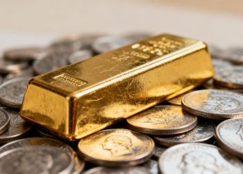 Barre d'or et pièces d'argent, symbole d'investissement.