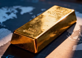 Lingot d'or sur fond flou de carte du monde.
