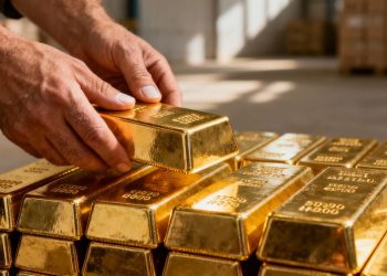 Mains plaçant une barre d'or sur une pile d'or.