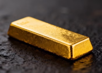 Lingot d'or brillant sur fond sombre.