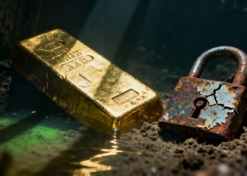 Lingot d'or dans l'eau avec un cadenas rouillé.
