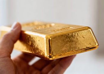 Barre d'or brillant tenue dans une main.