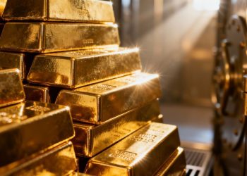 Lingots d'or dans un coffre-fort, éclairés par la lumière.