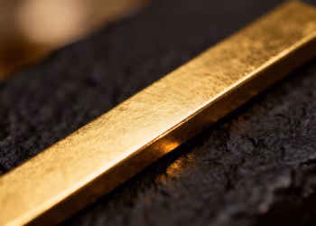 Lingot d'or brillant sur fond sombre.
