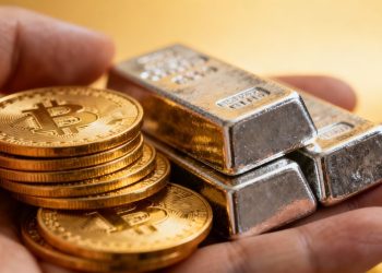 Main d'or tenant des pièces d'or et des lingots d'argent.