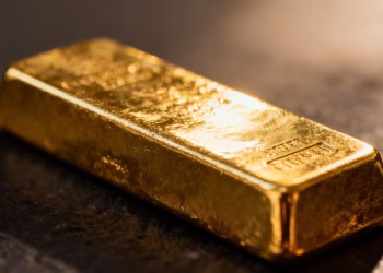Lingot d'or brillant sur fond sombre.