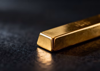 Lingot d'or brillant sur fond sombre.