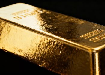 Lingot d'or brillant reflétant la lumière et l'ombre.