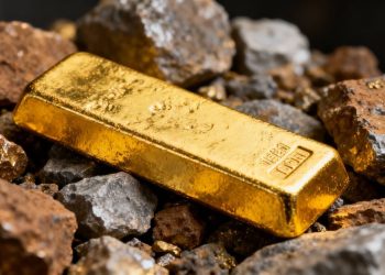 Lingot d'or sur fond de minerai brut.