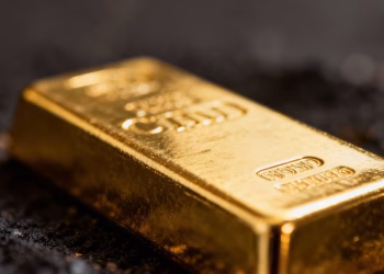 Lingot d'or brillant sur fond sombre.