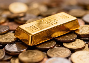 Lingot d'or sur des pièces de monnaie, investissement responsable.