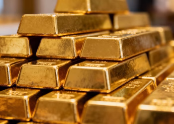 Barres d'or empilées, gros plan, brillance métallique.