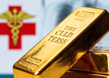 Lingot d'or avec symbole médical flou en arrière-plan.