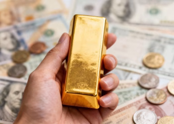 Main d'or tenant une barre d'or avec des actifs financiers diversifiés.