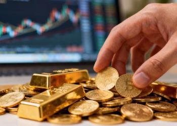 Pile de pièces d'or et barres avec une main les sélectionnant.