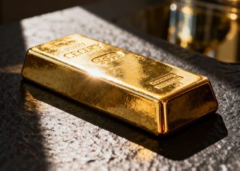 Lingot d'or brillant sur fond sombre.