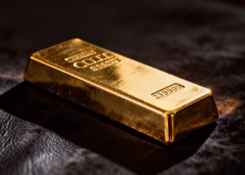 Lingot d'or brillant sur fond sombre.