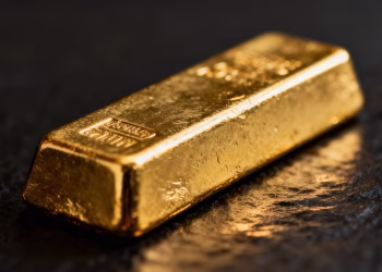 Barre d'or sur fond sombre, reflets lumineux.