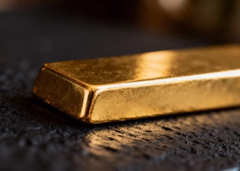 Lingot d'or brillant sur fond sombre.