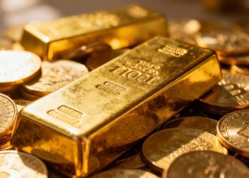 Lingots et pièces d'or brillants sous la lumière.