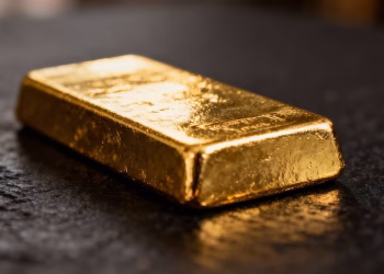 Lingot d'or brillant sur fond sombre.