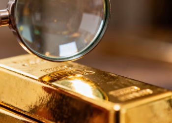 Lingot d'or sous une loupe pour vérifier sa pureté.