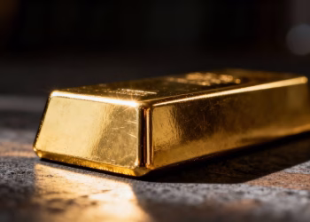 Lingot d'or brillant sur fond sombre.