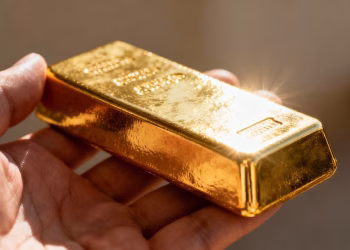 Barre d'or brillante tenue dans une main.