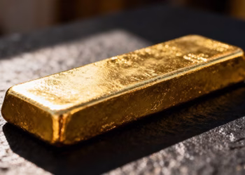 Lingot d'or brillant sur fond sombre.