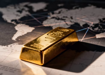 Lingot d'or sur fond de carte du monde floue.