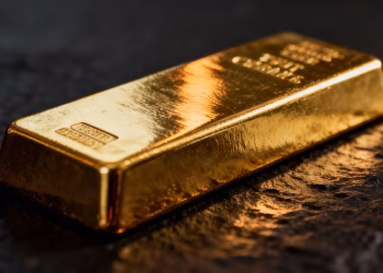 Lingot d'or brillant sur fond sombre.