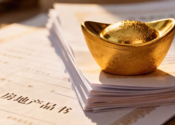 Lingot d'or sur des documents immobiliers.